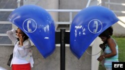 Dos mujeres hablan en La Habana en cabinas telefónicas públicas que pertenecen a la empresa de Telecomunicaciones de Cuba (ETECSA). EFE/Alejandro Ernesto