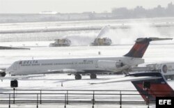 Máquinas quitanieves trabajan en una de las pistas del aeropuerto JFK de Nueva York, Estados Unidos.