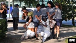 Miembros de la Policía y de la seguridad cubana disuelven por la fuerza una protesta de las Damas de Blanco en La Habana, donde reclamaban la libertad de los presos políticos. EFE/Alejandro Ernesto